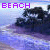 Pixelated image with purple 'BEACH' text at top, dark abstract shapes resembling rocks or cliffs against a blue-purple gradient background.