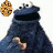 Two dark blue cartoon characters with large mouths and white eyes, one holding a cookie while the other has a red heart above its head.