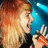 Pixelated image of a person with long light brown hair holding an orange microphone against a blue background, next to pixelated text reading "Cuz I got you were I wanted you now".