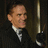 A four- shows a man in a black suit with a white shirt and black tie, holding a cane, with 'ASCOT' text in white block letters on the right . The man's head position changes , and the rightmost shows a different hand position on the cane