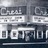 Pixelated grayscale image of a sign with partially legible text, showing fragmented letters and numbers against a dark background.