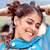 Pixelated static image of a person with brown hair in pigtails wearing a blue top, smiling with eyes closed against a light background.