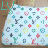 Pixelated patterned icon with repeating geometric shapes and stylized 'LV' logo elements in green, brown, pink, blue, yellow on light background.