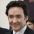 Static 50x50 pixel icon showing a close-up of a person with dark hair wearing a white shirt and dark jacket against a light background.