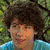 Four distinct portrait images of a young man with dark curly hair, each in different clothing and backgrounds arranged in a
