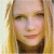 Pixelated close-up of a person with long blonde hair, light skin tone, and visible facial features including eyes, nose, mouth, and eyebrows.