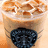 A pixelated image of a coffee drink with a blue heart-shaped object on a light background, accompanied by text elements.