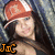Pixelated image of a person with long dark hair wearing a red cap, with orange text 'Joc' at bottom left.