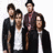 Four pixelated figures in formal attire stand closely together against a plain white background, with two wearing dark jackets over light shirts and two in darker tops.