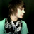 Pixelated static icon of a person with brown hair wearing a light green top and dark patterned garment, set against a black background.