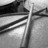 Grayscale pixelated image showing a vertical pole with diagonal lines extending from it, set against a light background.