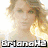 Pixelated image of a woman with blonde hair and text overlays reading 'BrianaH2', 'Is Taylor Swift's', and 'No.1 Fan!' in blocky font.