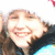 Pixelated close-up of a smiling person with light skin, brown hair, and dark clothing against a bright background.