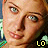 A pixelated close-up of a person's face with light blue eyes and a slight smile, featuring the text 'LO' in yellow, white, and green across different sections.