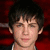 Pixelated image of a person with dark hair against a red background, with blue text reading "LOGAN LERMAN!" and green text reading "as Percy Jackson" on a black background.