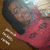 Pixelated image of a person in red clothing with dark hair, holding hands near the chest against a brown background; text "-jamma" appears at bottom right.