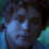 A pixelated image of a person with curly hair in blue-toned clothing against a dark background, with text reading "No Strings Attatched" on the right.
