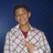 Pixelated static image of a person in white patterned shirt with red collar against dark blue background.