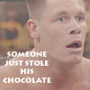 A close-up of a person with short light brown hair and blue eyes, wearing no shirt, with text overlaid in white pixelated font.