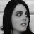 Static grayscale image of a person with long dark hair, neutral expression, and visible facial features including eyes, nose, and mouth.
