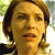 Pixelated close-up of a person with light brown hair and a neutral expression against a blurred background with green and yellow tones.
