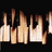 A static pixelated image of multiple vertical flame-like shapes against a black background, with varying heights and light brown to white color gradients.