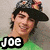 Two side-by-side pixelated images of people with text labels below each, one in green shirt and hat, the other in dark jacket and sunglasses.