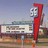 A pixelated static image shows a red vertical sign with a white face-like figure above a building with a large sign reading '56 Auto Drive-In' under a light blue sky.