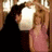 Animated sequence showing two figures in a dimly lit room with wooden paneling, one figure leaning toward the other as they interact.