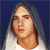 Pixelated portrait of a person with long dark hair against a solid blue background, wearing a white top.