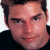A 50x50 pixel buddy icon featuring a split composition with a person's face on the left and green text on a dark background on the right.
