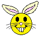Yellow bunny face with pink inner ears and nose, black eyes, white teeth, gray whiskers on a gray background.