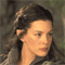 Pixelated close-up of a person with dark hair tied back, wearing a light-colored garment against a muted background.