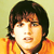 Pixelated static image of a person with dark hair and an orange top against a light background.