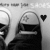 Black-and-white pixelated image showing a stylized figure with dark hair and a white headband, holding a black heart shape against a light background.