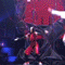 A performer in red clothing sings on a stage with dark, twisted tree-like structures and shifting red-and-white backdrops.