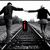 Black-and-white image of four people holding hands on train tracks with red text elements changing across frames.
