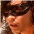 Pixelated close-up of a person with dark hair and light skin, wearing a dark headband and holding a light-colored object near their face.