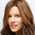 Pixelated close-up of a person with long brown hair, light skin, and a black top against a white background.