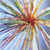 A pixelated static image with a central burst of warm colors radiating outward against a light blue background.