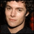 A 50x50 pixel buddy icon featuring a split composition with a person's face on the left and bold text on a yellow background on the right.