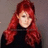 A person with long red hair and a black top appears in four -aligned showing subtle facial expression changes against a gray background