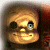 Pixelated cartoon face with one eye closed, one eye open, and a wide smile, set against a dark background with brown and red tones.