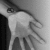 A grayscale pixelated image of a figure in motion, with blurred limbs suggesting rapid movement against a light background.