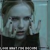 A static image shows a person with light brown hair holding both hands near their face, wearing a dark top, with pixelated text at the bottom reading "LOOK WHAT I'VE BECOME".