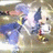 Pixelated static image of a character with blue hair and white clothing against a blurred background.