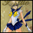 Pixelated anime character in sailor uniform with blue skirt, white top, yellow bow, and blue collar, standing against beige background with black text overlay.