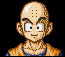 Pixelated character with bald head, three dots on forehead, thick eyebrows, and orange martial arts uniform against black background.