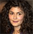 A pixelated close-up of a person with dark curly hair, light skin, and a neutral expression against a dark background.