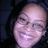Pixelated close-up of a smiling person with light skin and dark hair against a dark background.